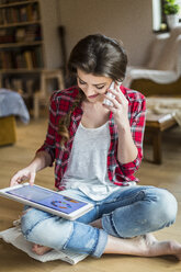 Junge Frau zu Hause bei der Arbeit mit einem digitalen Tablet - HAPF000277