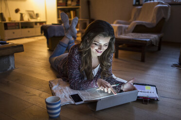 Junge Frau zu Hause bei der Arbeit mit einem digitalen Tablet - HAPF000296