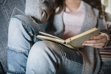 Junge Frau zu Hause beim Lesen eines Buches - HAPF000300