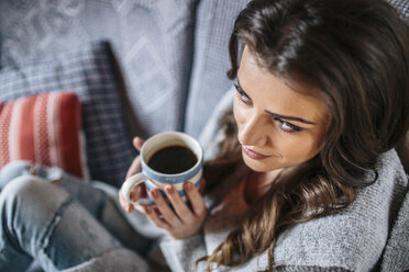 Junge Frau zu Hause, die eine Tasse Kaffee trinkt - HAPF000304