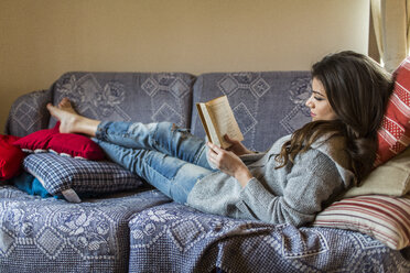 Junge Frau zu Hause beim Lesen eines Buches - HAPF000308