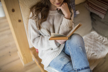 Junge Frau zu Hause beim Lesen eines Buches - HAPF000310
