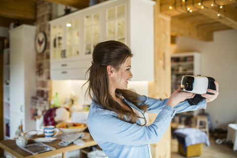 Junge Frau zu Hause mit Virtual-Reality-Brille, lizenzfreies Stockfoto