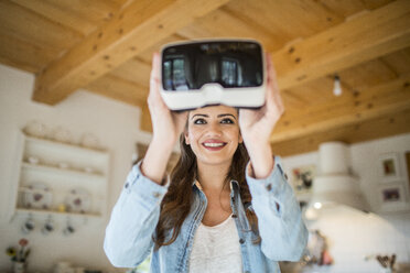 Junge Frau zu Hause mit Virtual-Reality-Brille - HAPF000330