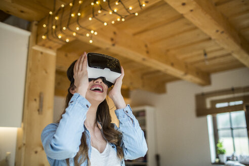 Junge Frau zu Hause mit Virtual-Reality-Brille - HAPF000332