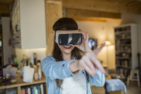Junge Frau zu Hause mit Virtual-Reality-Brille - HAPF000333