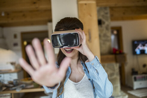 Junge Frau zu Hause mit Virtual-Reality-Brille - HAPF000334