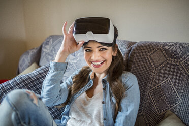 Junge Frau zu Hause mit Virtual-Reality-Brille - HAPF000335