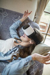 Junge Frau zu Hause mit Virtual-Reality-Brille - HAPF000337