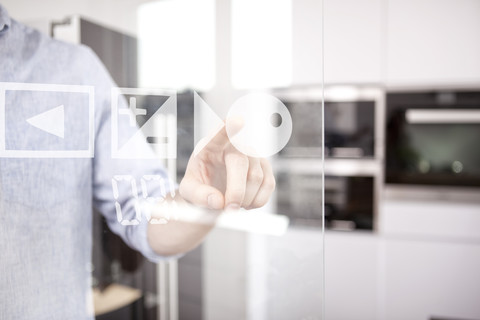 Männerhand benutzt den Touchscreen des Backofens in seiner Küche, lizenzfreies Stockfoto
