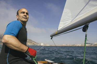 Mann segelt mit seinem Segelboot auf dem Meer - ABZF000324