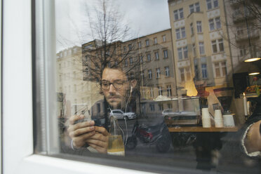 Mann in einem Cafe hinter Fensterscheibe - JUBF000135