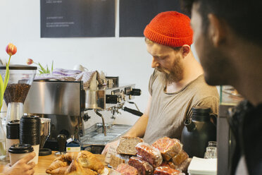 Barista hinter dem Tresen eines Cafés - JUBF000137