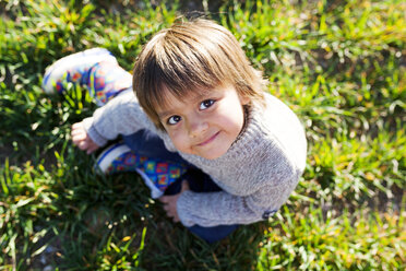 Portrait of smiling boy sitting in meadow - VABF000412