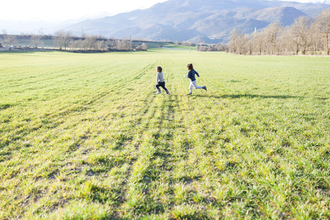 Zwei Jungen laufen auf einem Feld, lizenzfreies Stockfoto