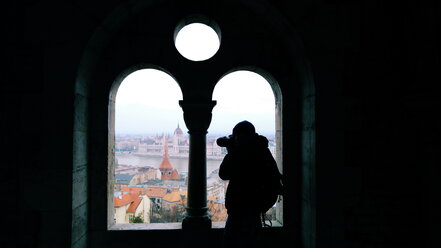 Budapest, Ungarn: Mann fotografiert das ungarische Parlamentsgebäude und die Stadt von einem Aussichtspunkt auf dem Budaer Burgberg aus - GEMF000822