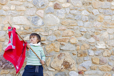 Portrait of little boy with red flag playing hero - VABF000416