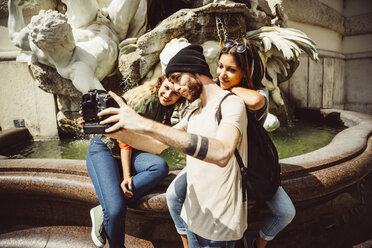 Österreich, Wien, Gruppe von drei Freunden, die ein Selfie vor dem Springbrunnen in der Hofburg machen - AIF000289