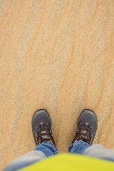 UAE, Rub' al Khali, man standing in the desert sand, partial view - MAUF000389