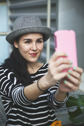 Porträt einer jungen Frau, die ein Selfie mit ihrem Smartphone macht, lizenzfreies Stockfoto