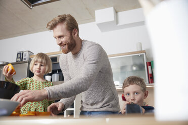 Vater und Kinder benutzen die Saftpresse in der Küche - RHF001381