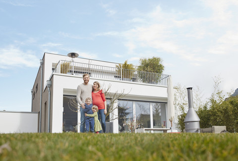 Porträt einer glücklichen Familie mit schwangerer Mutter im Garten, lizenzfreies Stockfoto