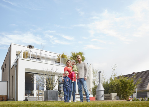 Portrait of happy family with pregnant mother in garden stock photo