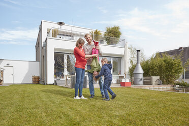 Porträt einer glücklichen Familie mit schwangerer Mutter im Garten - RHF001403