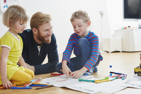 Vater auf dem Boden liegend mit malenden Kindern - RHF001445