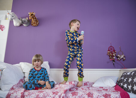 Bruder und Schwester im Pyjama im Kinderzimmer - RHF001464