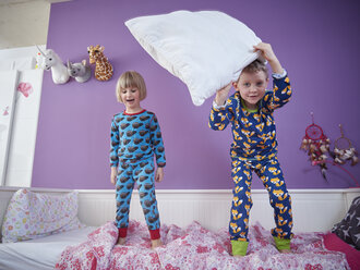 Bruder und Schwester im Schlafanzug beim Herumtollen im Kinderzimmer - RHF001466