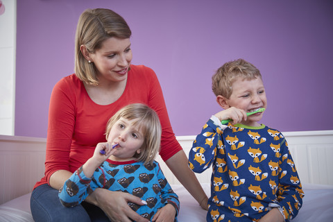 Mutter mit zwei Kindern beim Zähneputzen, lizenzfreies Stockfoto