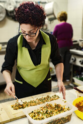 Woman preparing filled focaccia in canteen kitchen - CSTF001030