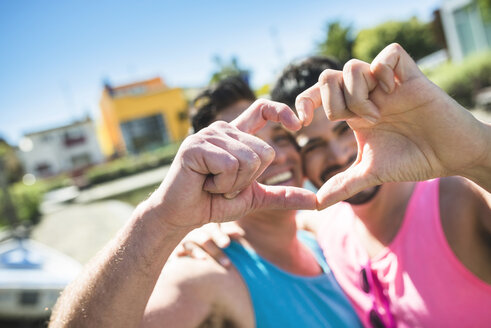 Gay couple in love shaping heart with their fingers - LEF000062