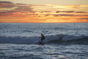 Mann surft bei Sonnenaufgang - SKCF000082