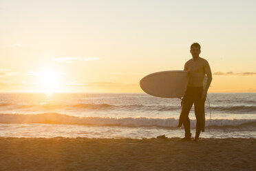 Surfer bei Sonnenaufgang am Strand stehend - SKCF000086