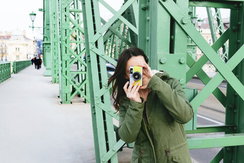 Ungarn, Budapest, Junge Frau auf Freiheitsbrücke beim Fotografieren - GEMF000825