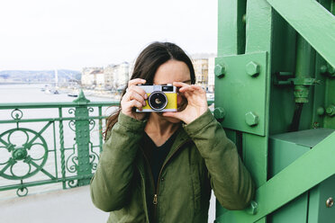 Ungarn, Budapest, Junge Frau auf Freiheitsbrücke beim Fotografieren - GEMF000828