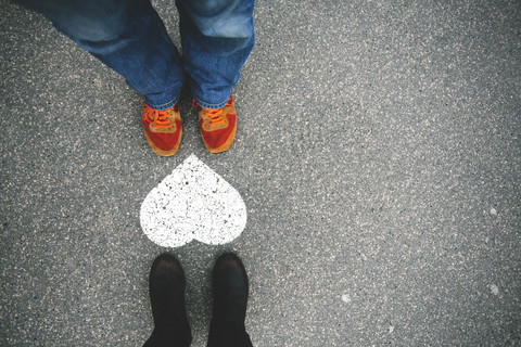 Hungary, Budapest, Feet of man and woman standing by heart on tarmac stock photo