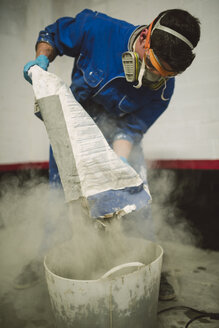 Bricklayer pouring cement powder in bucket - RAEF001010