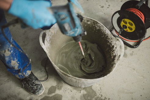 Bricklayer mixing cement in bucket - RAEF001016