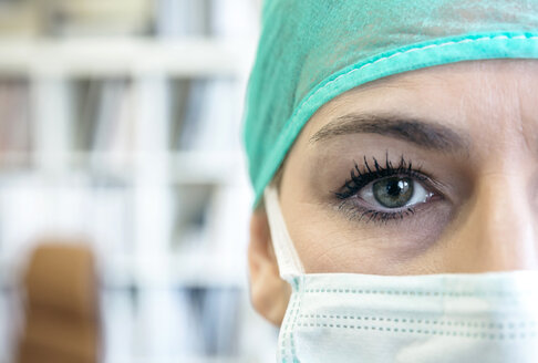 Close-up portrait of doctor wearing mask and surgical cap - DAPF000064