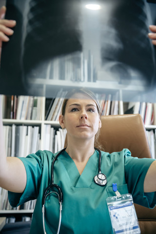 Arzt beim Betrachten eines Röntgenbildes, lizenzfreies Stockfoto