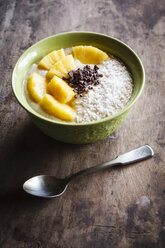 Bowl of fruit smoothie garnished with pineapple slices, coconut flakes and chocolate shaving - EVGF002909