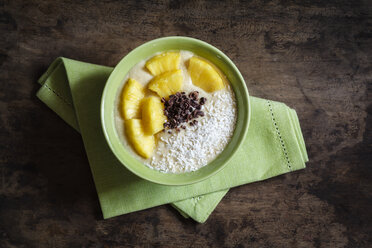 Bowl of fruit smoothie garnished with pineapple slices, coconut flakes and chocolate shaving - EVGF002911