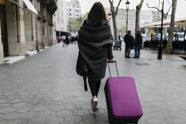 Spanien, Barcelona, junge Frau mit Koffer beim Spaziergang in der Stadt - JRFF000511