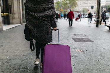 Spanien, Barcelona, junge Frau mit Koffer beim Spaziergang in der Stadt - JRFF000512