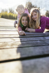 Group picture of three girls on a boardwalk pulling funny faces - MGOF001709