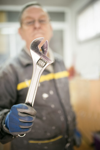 Senior man holding pliers stock photo