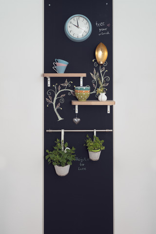 Wanddekoration mit Regalen und Kräutern auf Tafeln mit Lampe und Uhr, lizenzfreies Stockfoto
